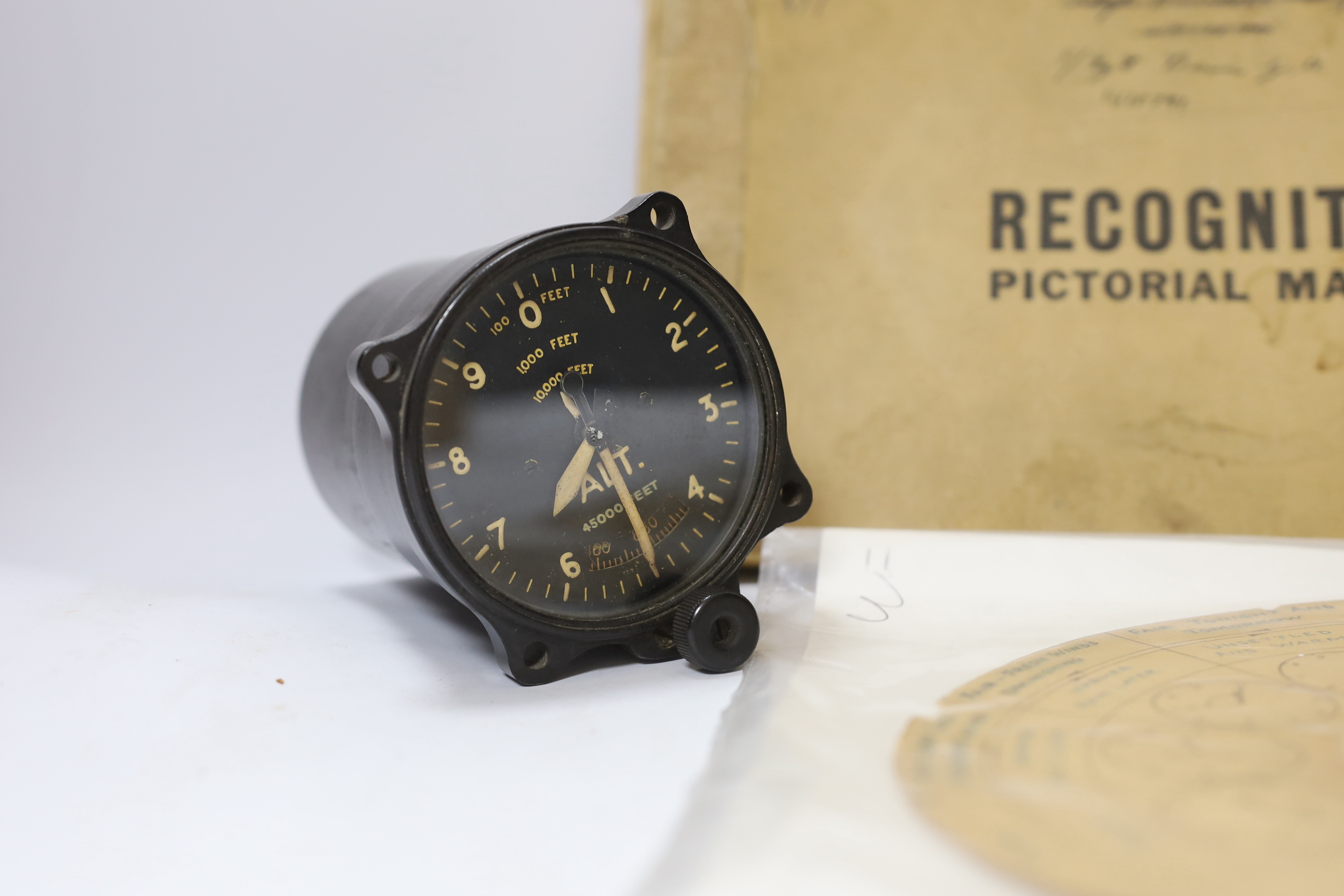 A WWII Air Ministry altimeter model XIV B and a War & Navy Department aircraft recognition pictorial manual